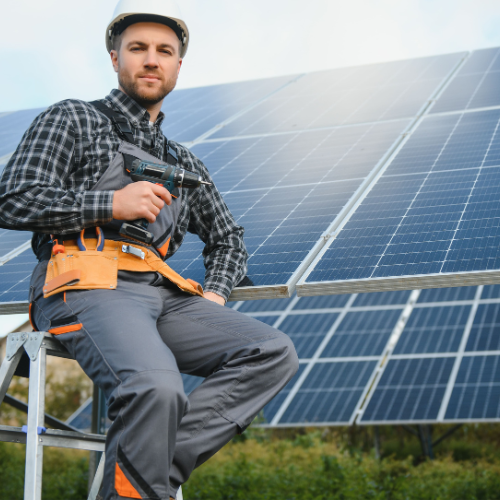 Técnico en energía solar posando delante de paneles fotovoltaicos
